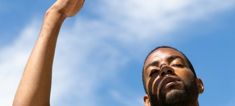 Picture of a person that is shielding themselves from the sun after moving to San Antonio 