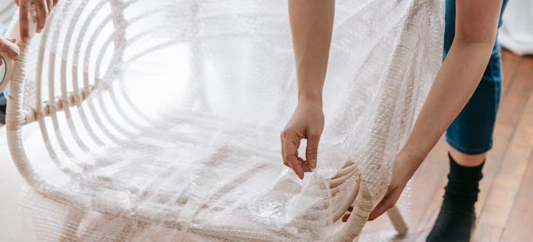 A person wrapping a chair for relocation