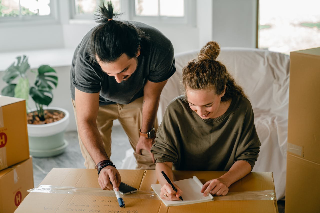 Two people making a packing supplies checklist for an office relocation