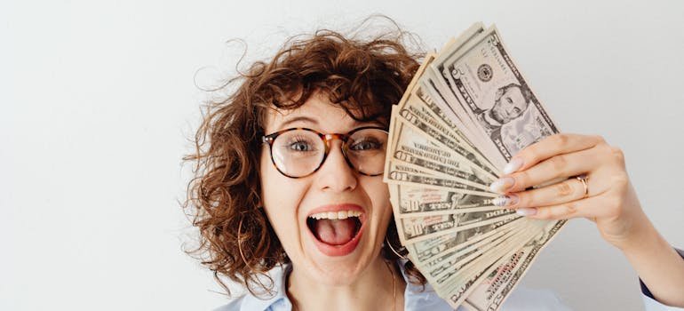 A happy woman holding dollar bills