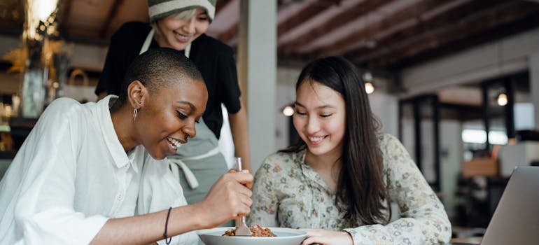 Two eomen tasting food