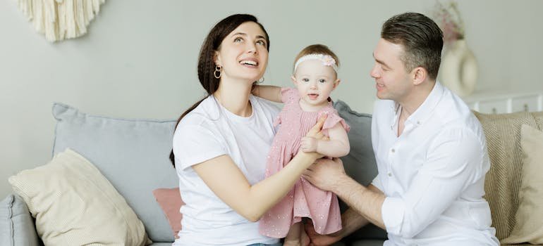 Parents with the baby talking about buying a home in San Antonio vs neighboring cities