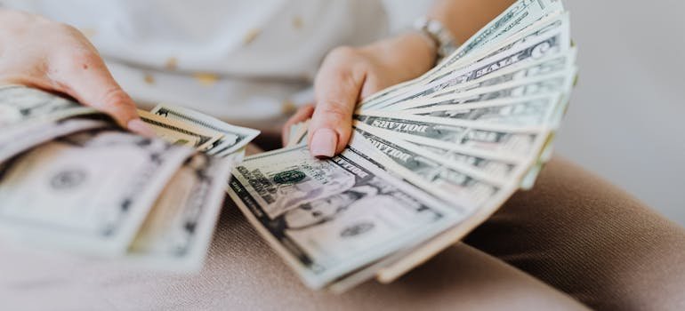 A person counting dollar bills 