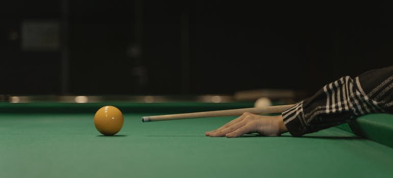 trying a ball on the pool table after settling into a new home