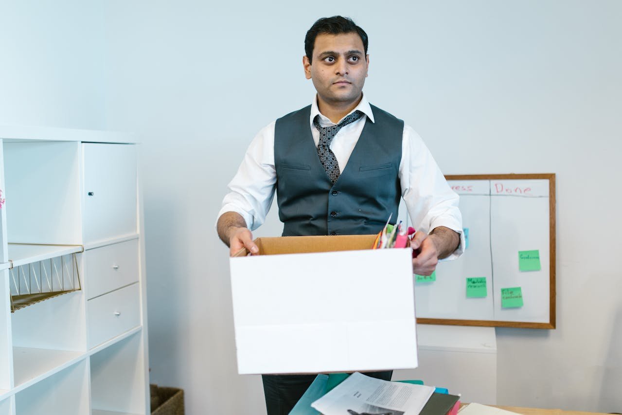 A man in the office packing a moving box