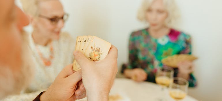 Seniors playing cards and talking about Schertz for retirees