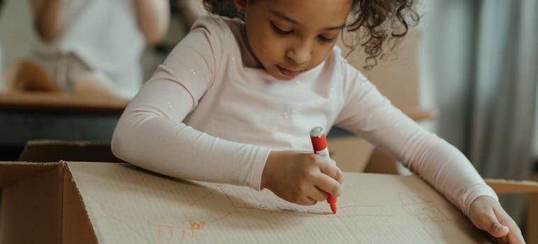 A kid writing on the moving box