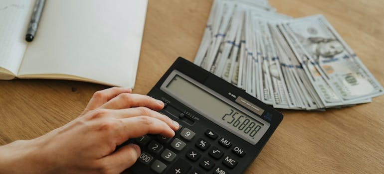 A person calculating hidden costs of DIY packing