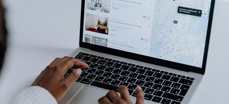 Person browsing apartment listings and a map on a laptop while researching the best time to move to Terrell Hills.