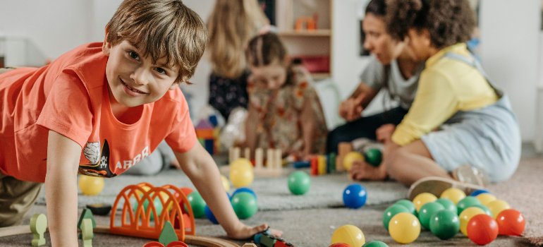 Children playing with colorful toys in a classroom setting, showing how keeping routines helps when moving with kids to Olmos Park.