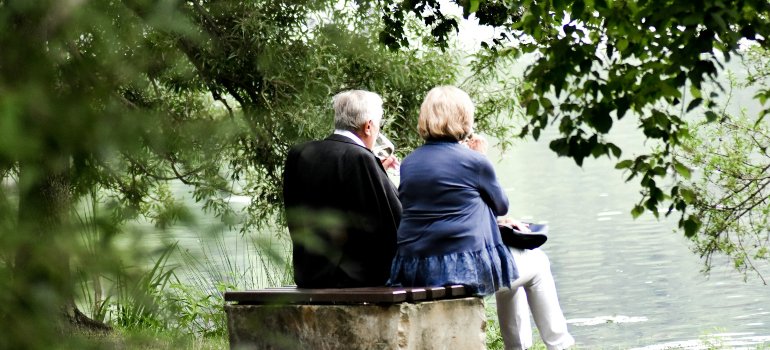 Senior couple sitting under a tree in safe and affordable cities in Bexar County for retirement
