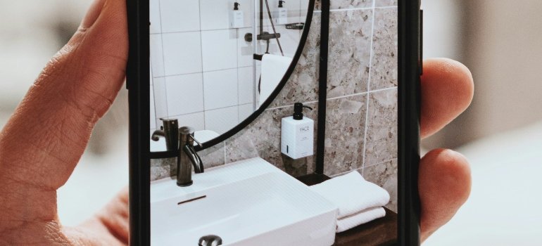 Person taking a picture of a bathroom sink