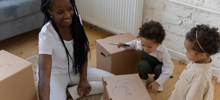 Mom and Toddlers Labeling Cardboard Boxes on the Floor While They Pack for a Move, When You Have a Toddler at Home