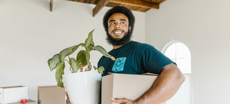 a mover holding a box and a pot