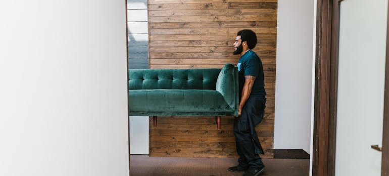 a mover carrying a sofa. Moving to Shavano Park from Floresville