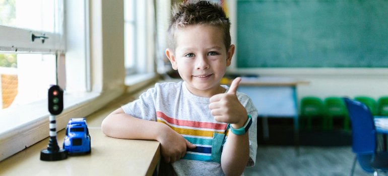 Little Boy in Gray Shirt in Thumbs Up Gesture