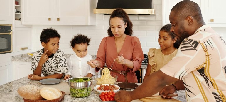 Find the right home in Converse with a family happily preparing food together in the kitchen.