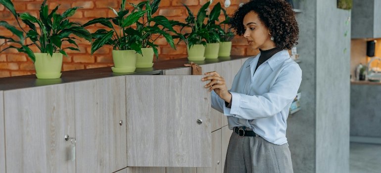 Curly Haired Woman Opening a Wooden Locker