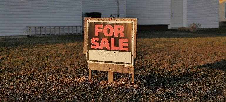 For sale sign placed in front of a house on a lawn, showing why your Converse house isn't selling.