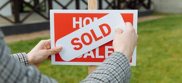 A realtor posting a SOLD sticker in the Spring Branch housing market. 