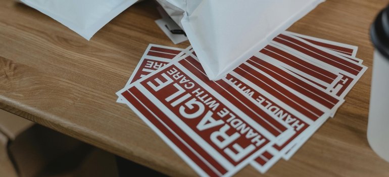 White and red fragile sign on a brown wooden table prepared for packing paintings and artwork during a move