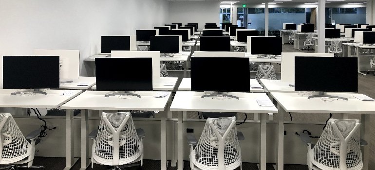 Modern office with multiple desks and computers arranged neatly after professional furniture installation.
