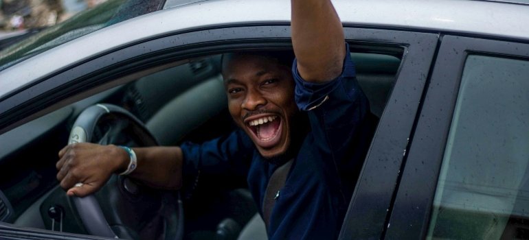 Picture of a happy person driving his car to one of the top San Antonio suburbs