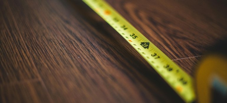 Close-up photo of measuring tape used to prevent wall damage when moving large furniture