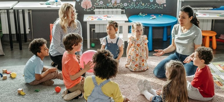 Kids with their Teacher Sitting on the Floor