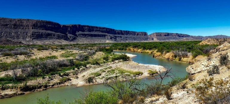 Body of Water Between 2 Mountains Under Clear Sky during Daytime