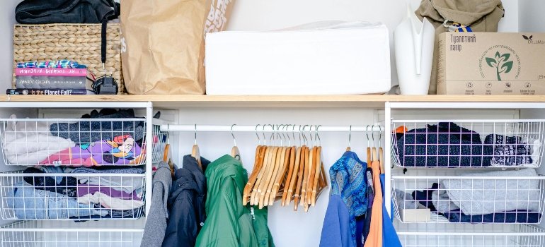 Closet with neatly sorted clothes and storage bins ready to downsize for a move in Lytle.