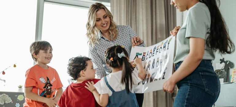 Teachers Holding a Poster of the Alphabets