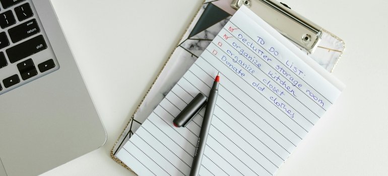 Handwritten planner showing a structured moving to-do list for an upcoming relocation.