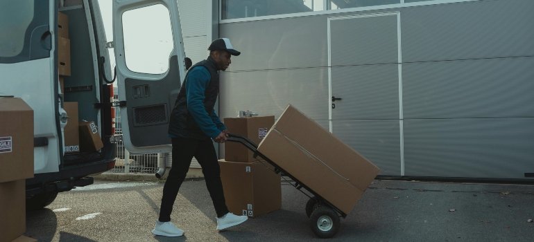 Movers using dollies and secure methods to manage weight and balance during transport.