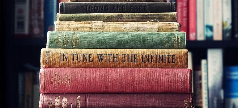 Vintage hardcover books lined on a shelf before homeowners pack books for moving in Helotes.